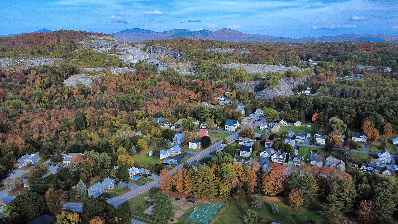 Graniteville seen from above, houses among autumn trees with the quarry beyond.