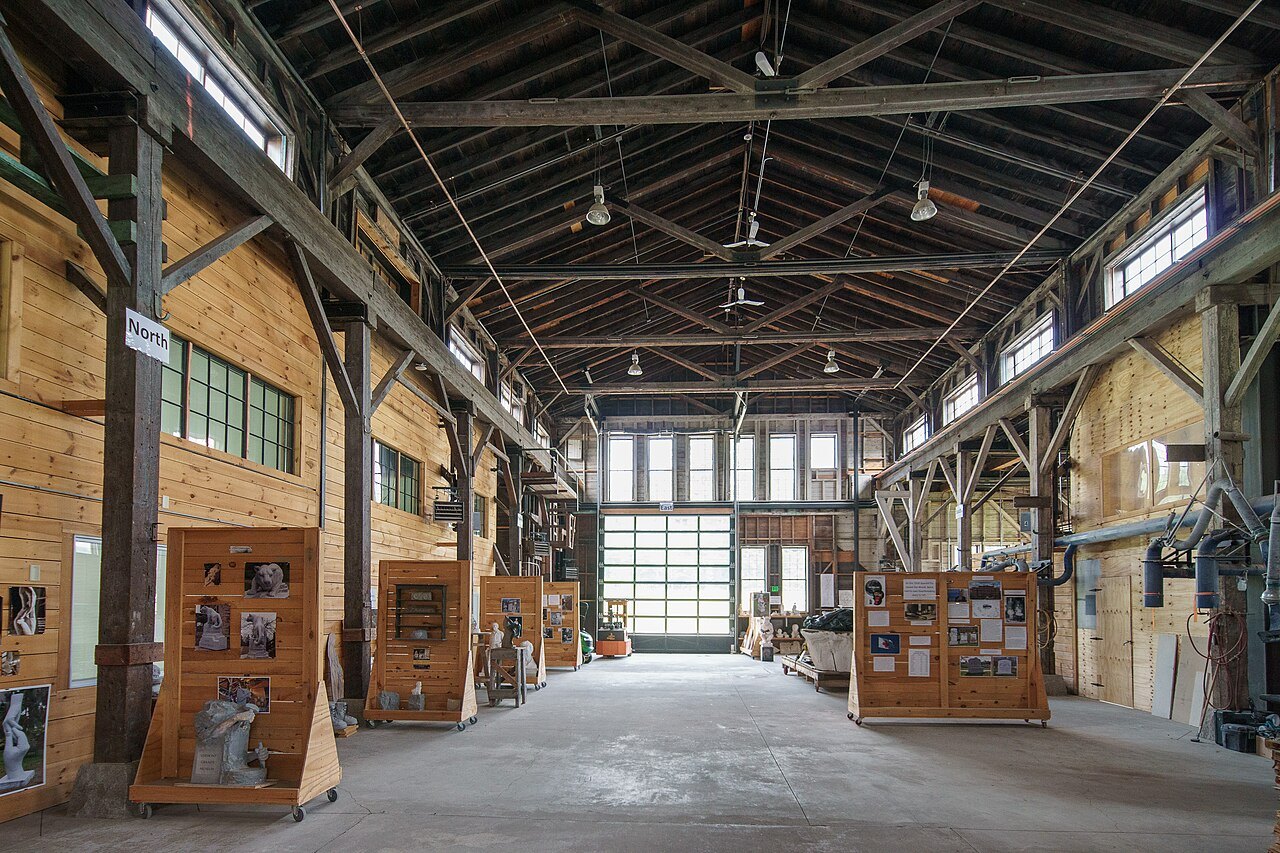 Inside the Jones Brothers granite shed, a long timber hall under a high roof, with exhibits along its sides.