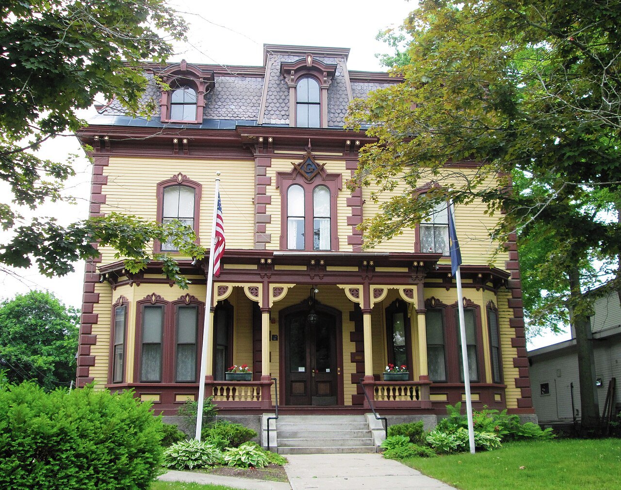 The Masonic Temple, a yellow Italianate house with a tower and porch, in Bellows Falls.