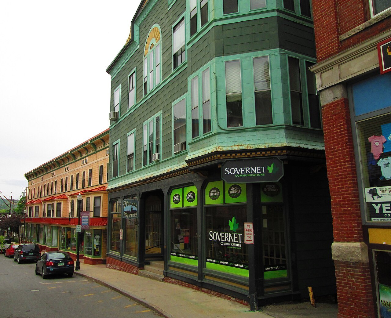 Canal Street from the south, a green-trimmed corner block above the street.