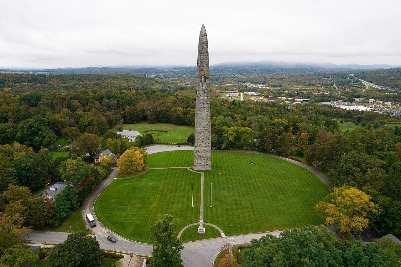 The monument rising above its oval lawn and a patchwork of autumn forest.