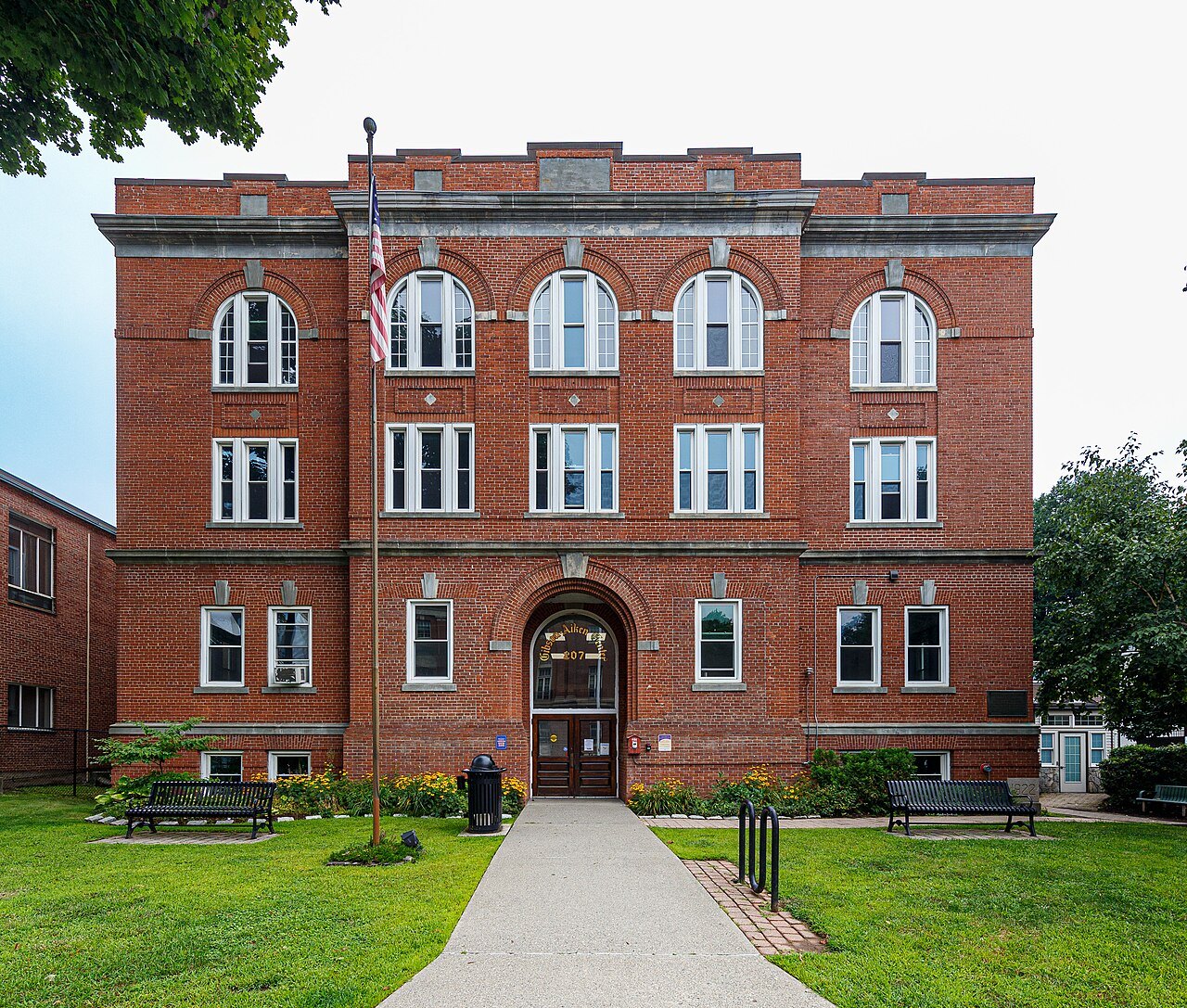 The Gibson-Aiken building, a red-brick hall with arched windows and a lawn path.