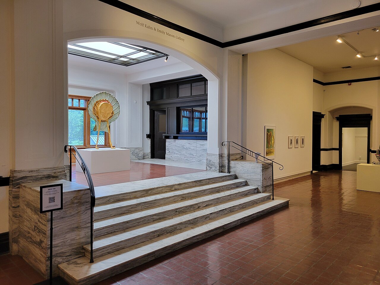 The museum's entrance hall, a wide stair rising to a bright gallery.