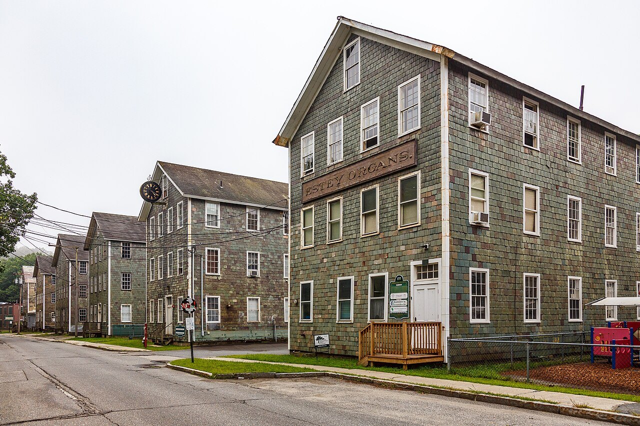 Estey Organ Company buildings, three-story mills of clapboard and shingle along a quiet street.