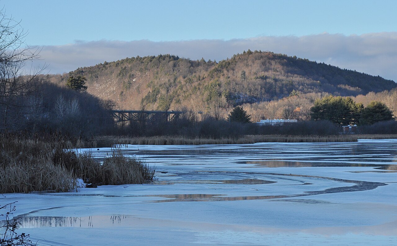 Ice on the Connecticut River in winter, blue and white sheets under pale hills.