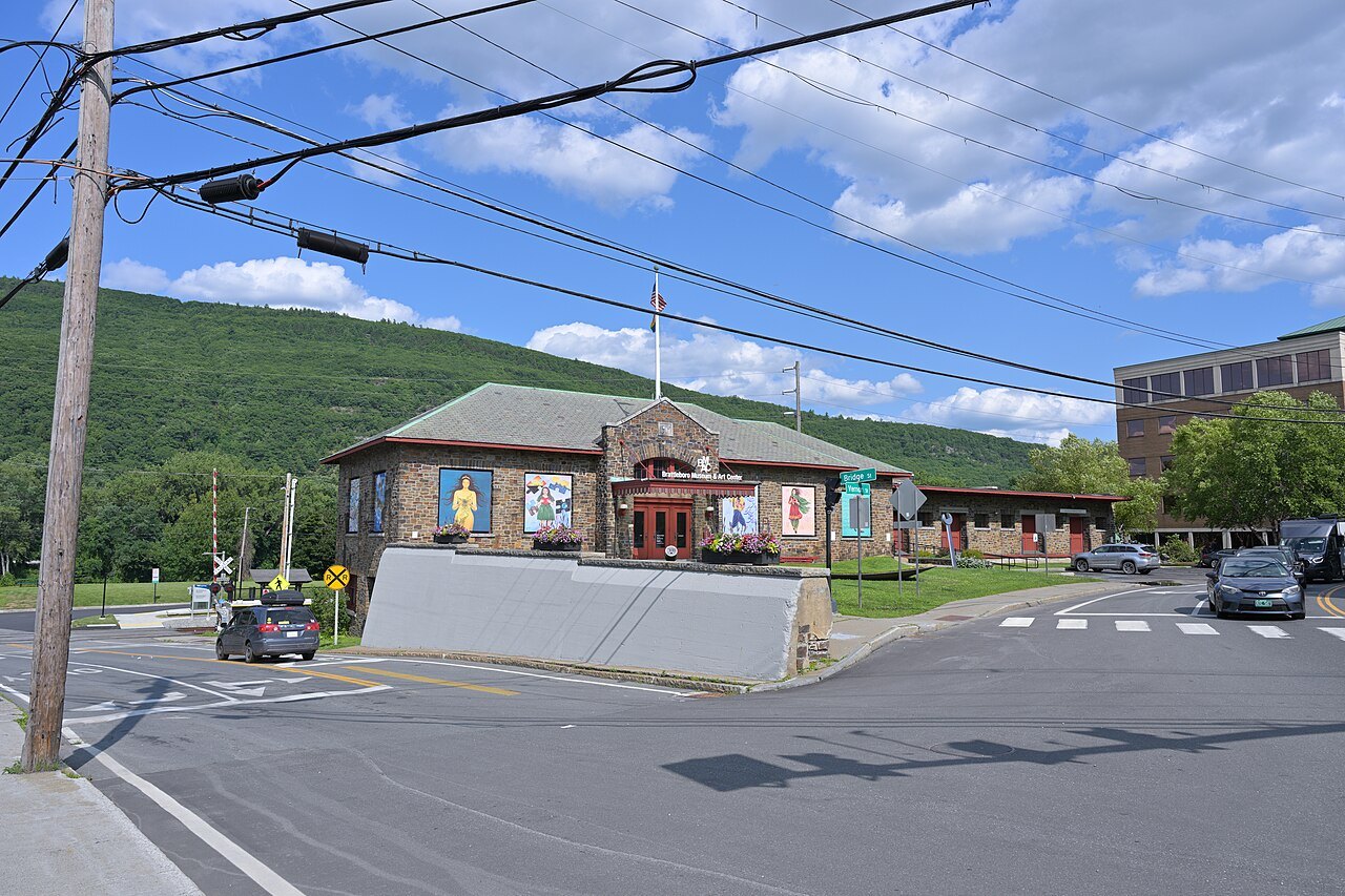 The Brattleboro Museum and Art Center, a low decorated building at a street corner under a green hill.