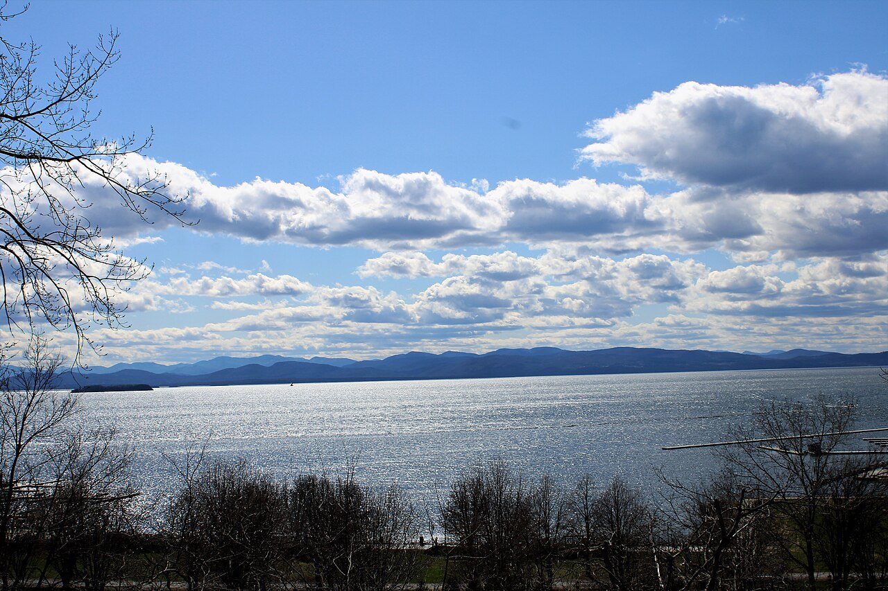 Lake Champlain from the Burlington shore, with the far mountains faint under broken cloud.