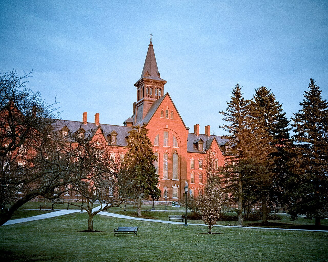 Old Mill at the University of Vermont, a brick building with a tall tower, on the green.