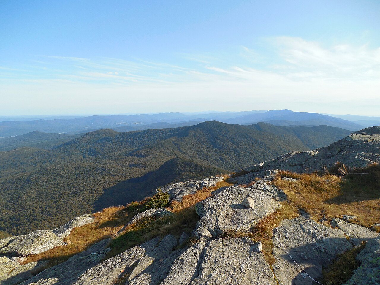 Bare rock on the summit of Camel's Hump, with ranges of hills stretching south.