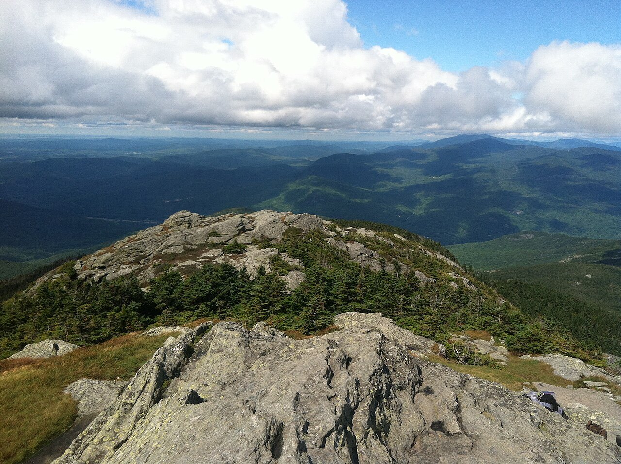 The rocky summit of Camel's Hump, with green ridges beyond.