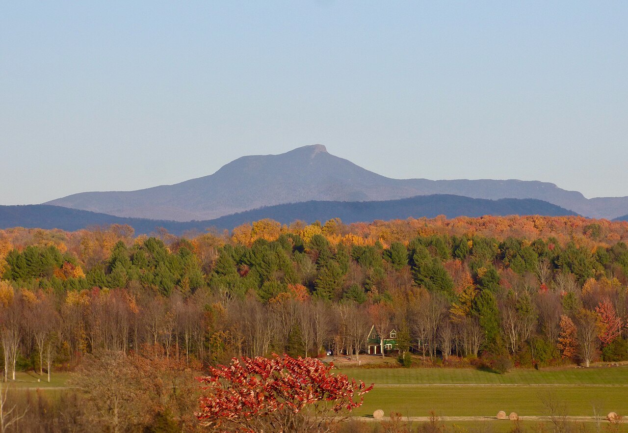 Camel's Hump above autumn forest, seen from the west across a field.