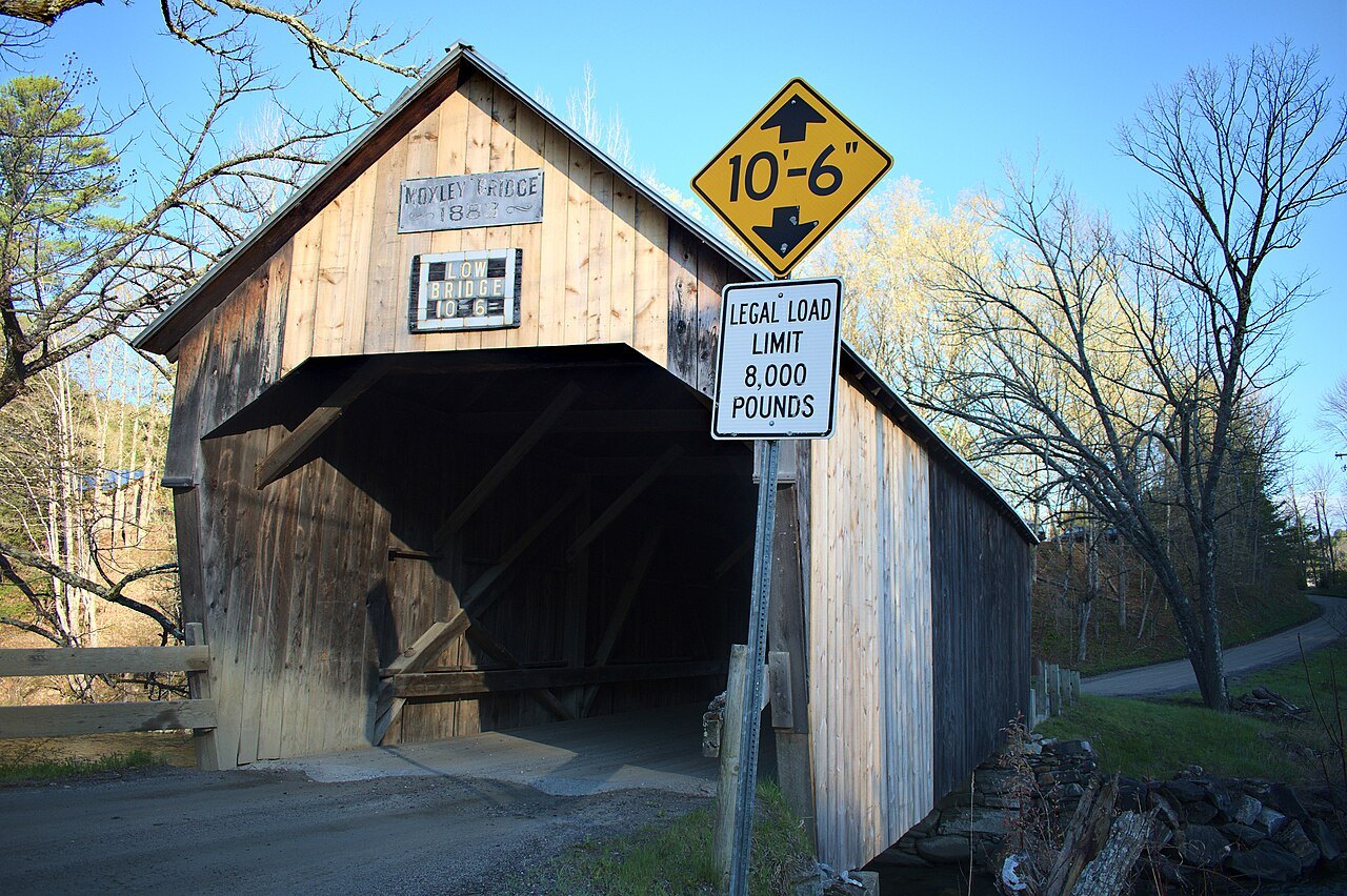 The Moxley Covered Bridge, with a weight-limit sign at its portal, beside bare trees.