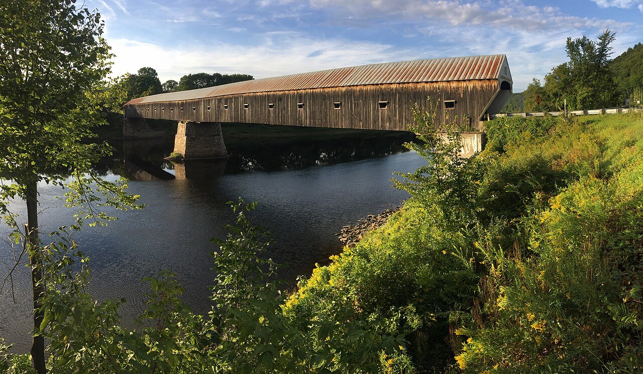 The Cornish–Windsor Covered Bridge over the Connecticut River, its long wooden roof seen from the bank.