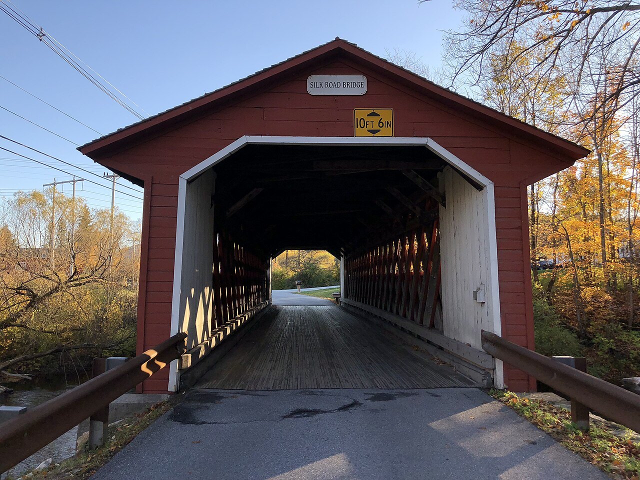 The north portal of the Silk Road Covered Bridge in Bennington, red with white trim and the road running through.