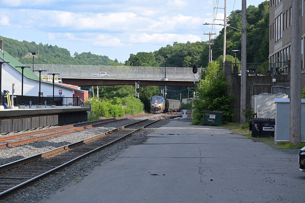 The Vermonter approaching the Brattleboro station along the tracks, under a highway bridge.