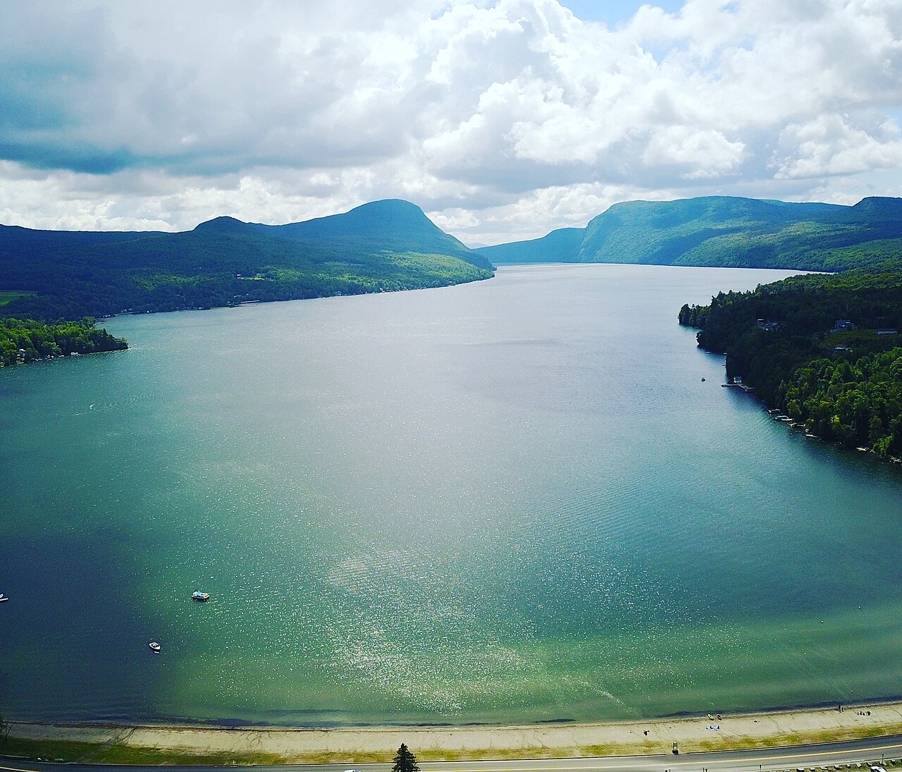 Lake Willoughby from the air in summer, a long green-blue lake between two forested mountains.