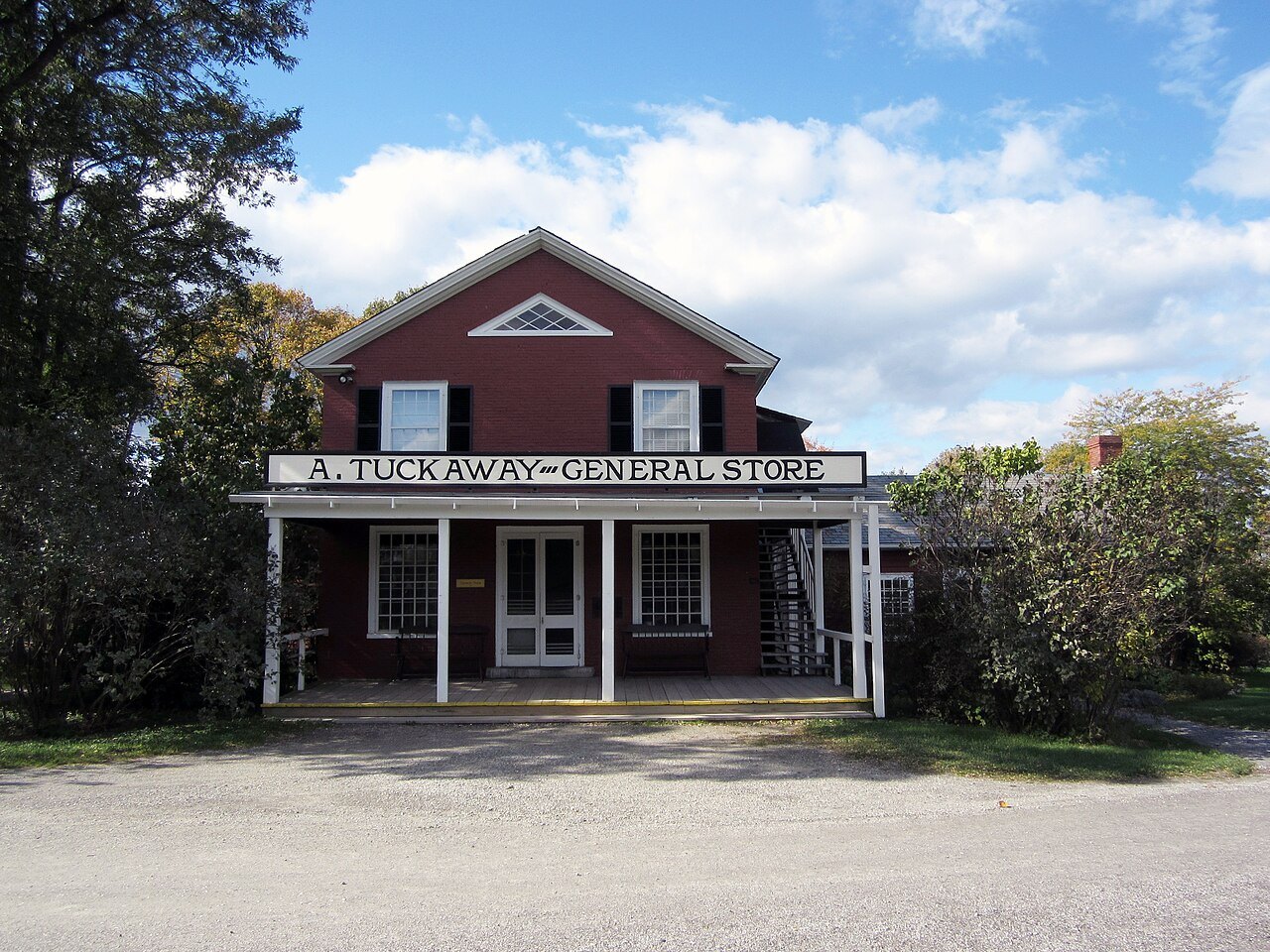 The Tuckaway General Store, a red building with a porch under a blue sky.