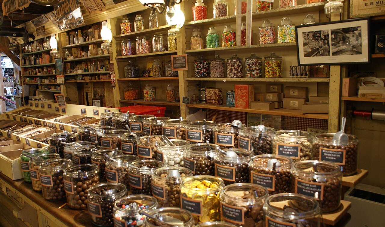The shelves and counter of an old general store, with jars of candy in rows.