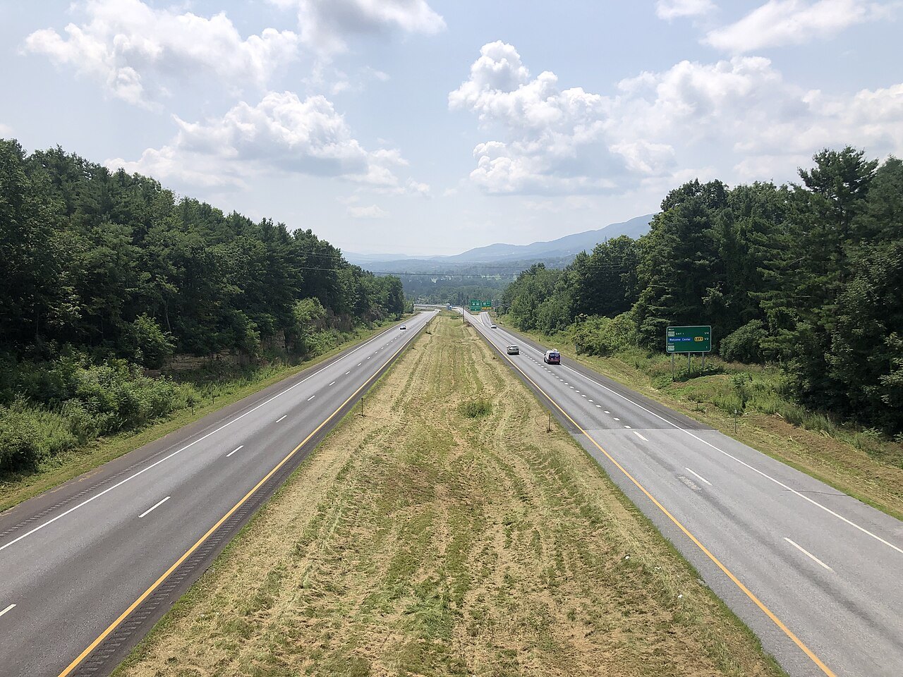 A divided highway running south through green hills on U.S. Route 7.