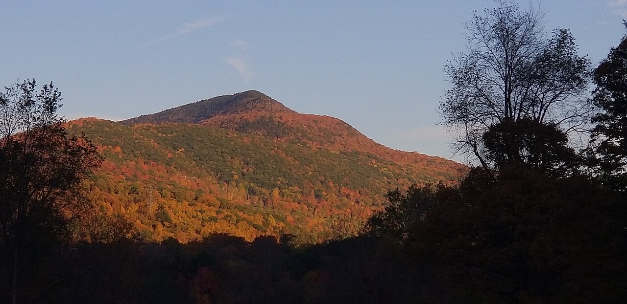 Mount Aeolus in autumn, lit orange against a dark foreground.