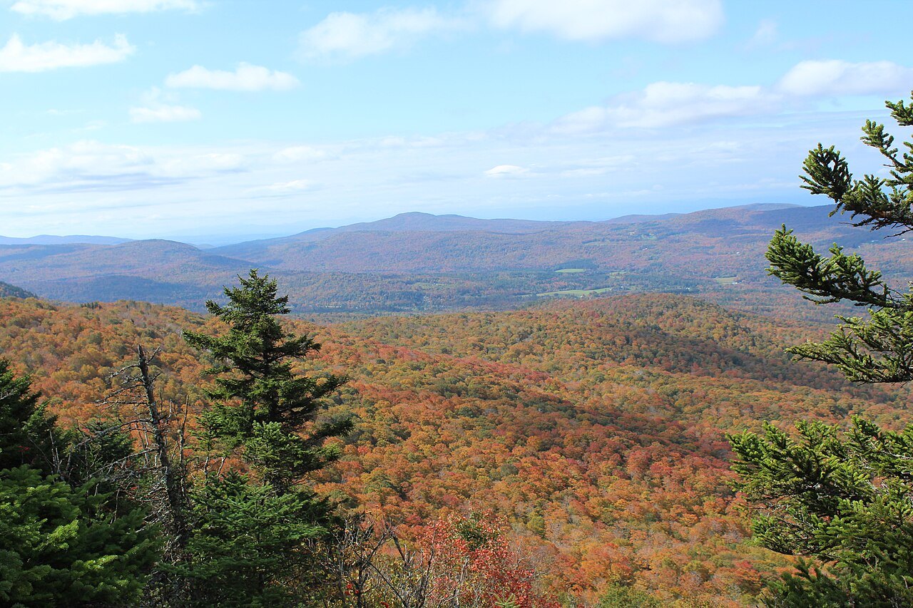 An autumn view from a rock ledge in the Green Mountain National Forest, with spruce at the right edge.