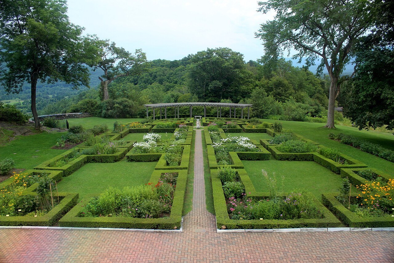 The formal garden from above, with boxwood hedges and a brick path.