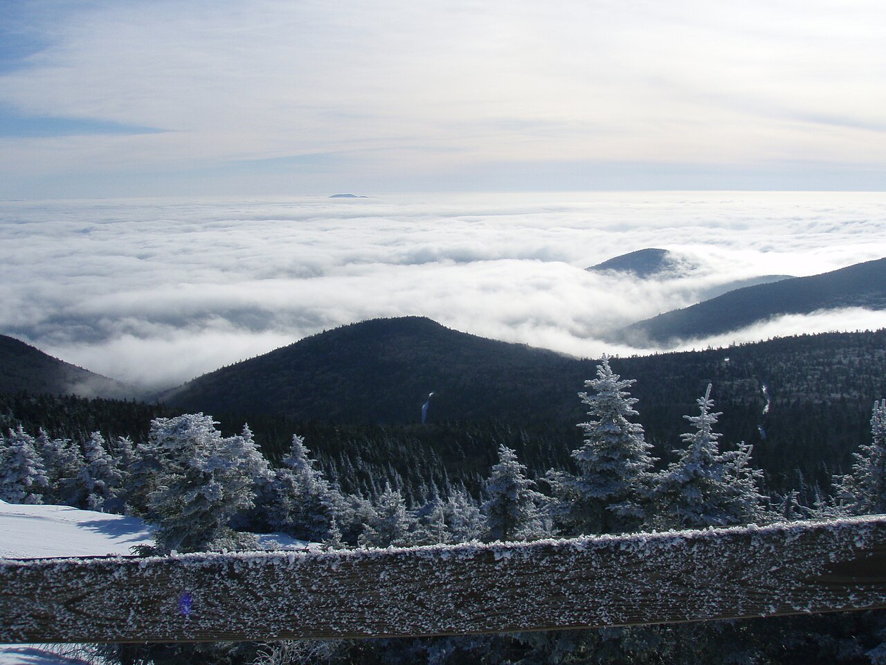 Cloud filling the valleys below Killington Peak on a winter day, with frosted spruce along the railing.