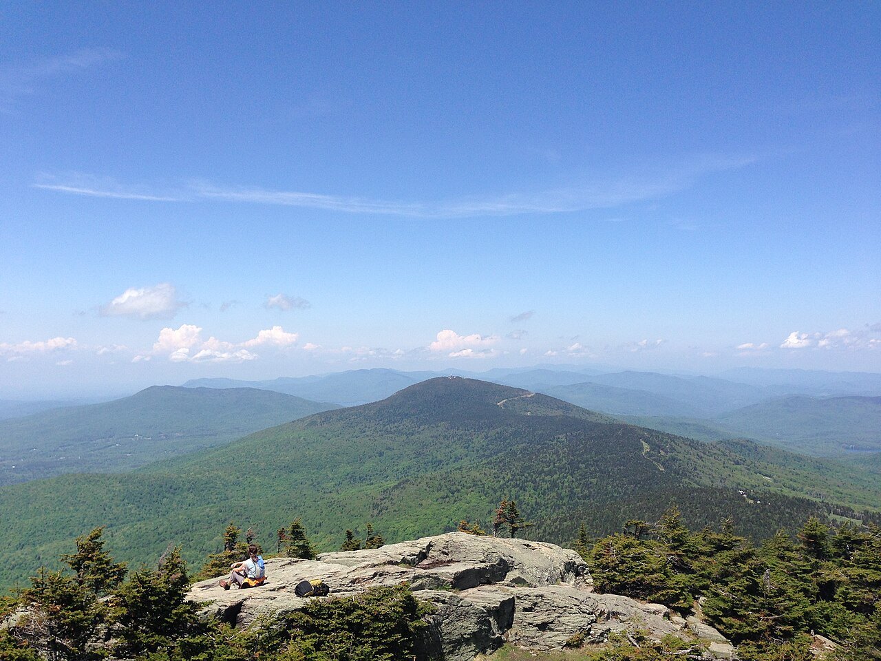 The view from Killington Peak toward Pico Peak, with green ridges under broken cloud.