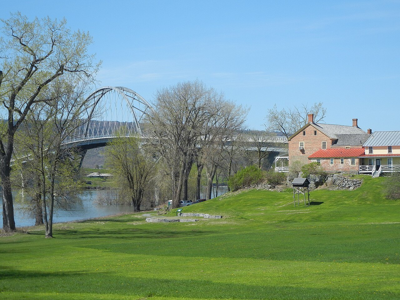The Chimney Point shore on the Vermont side, with the arch of the Lake Champlain Bridge behind the trees.