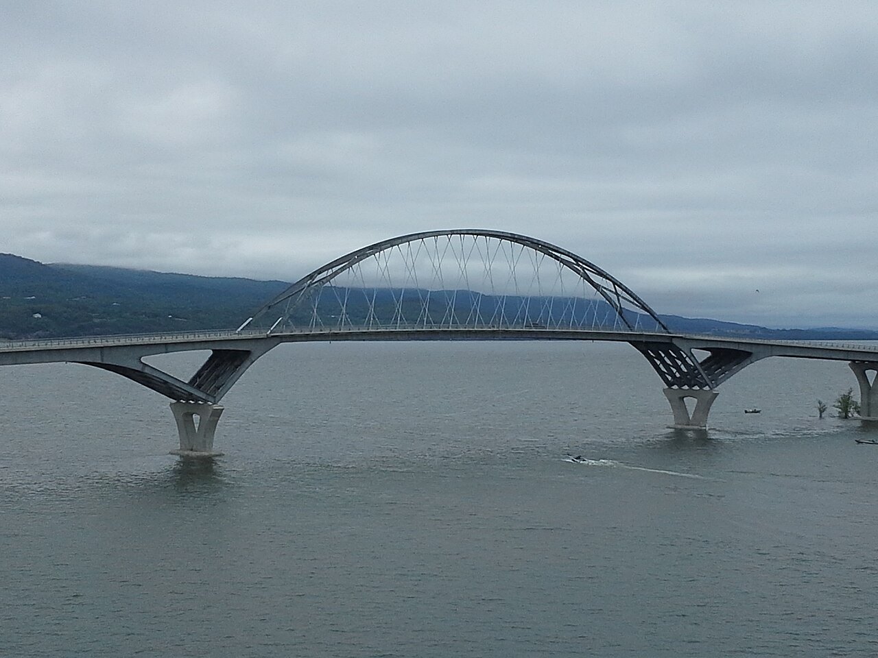 The Lake Champlain Bridge, a pair of white arches over gray water.