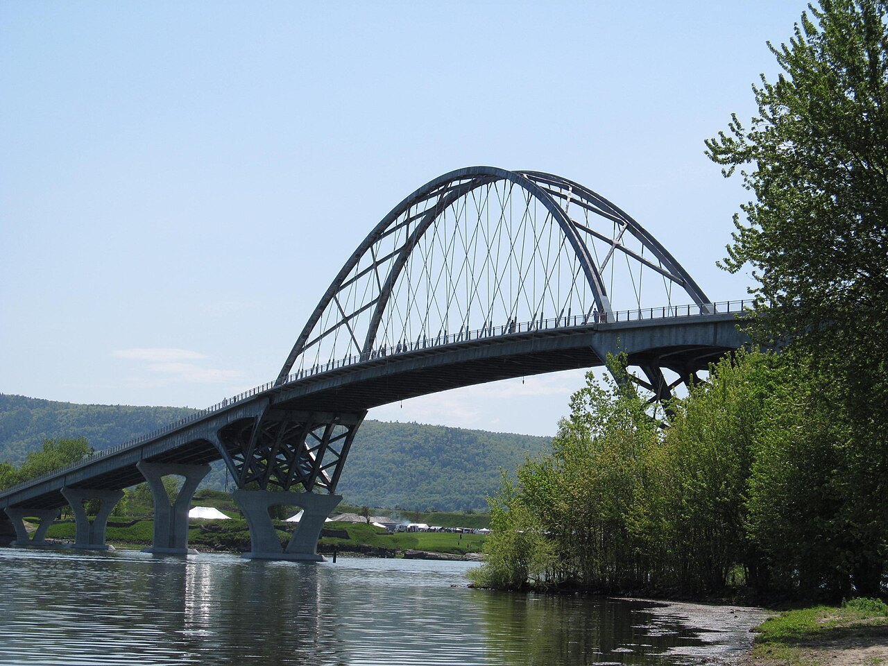 The Lake Champlain Bridge from the Vermont shore, with the arch rising above the trees.