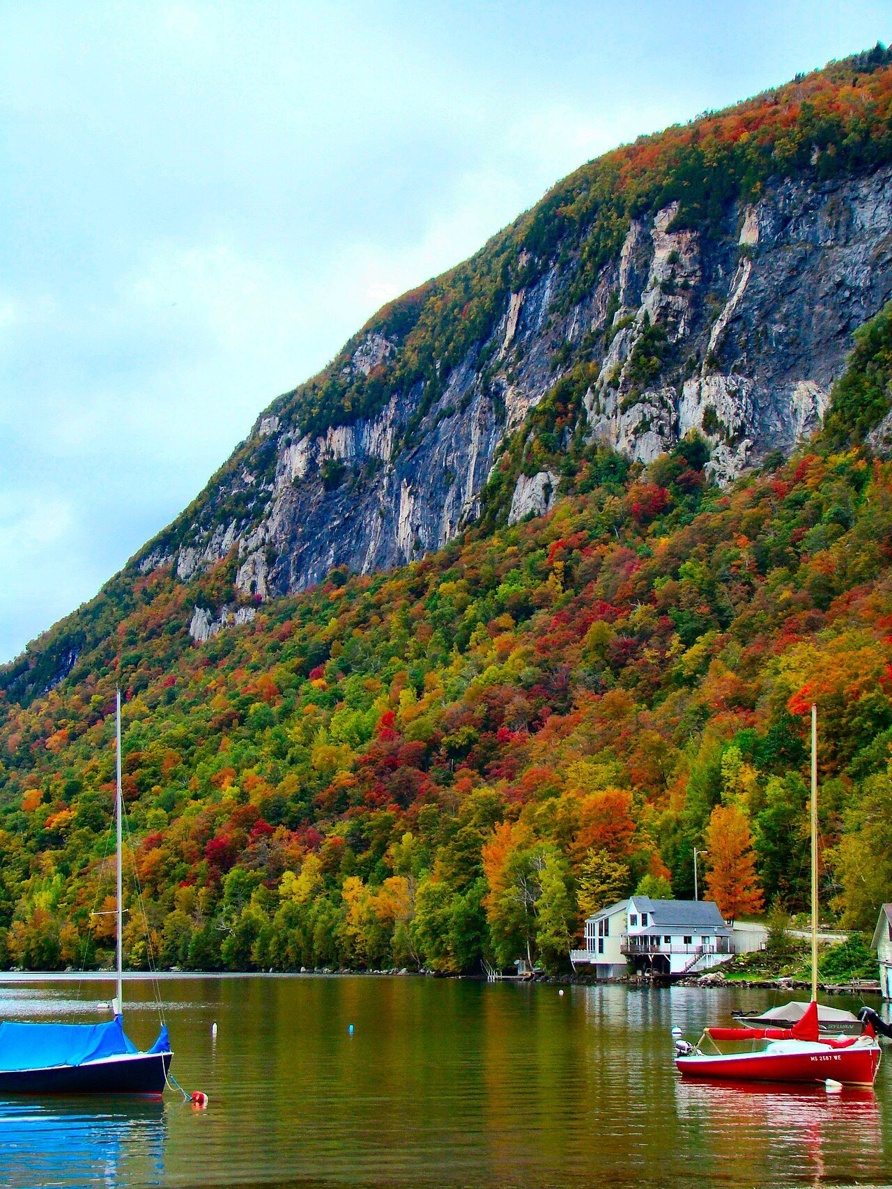 Pisgah's cliff above boats moored on the lake in autumn.