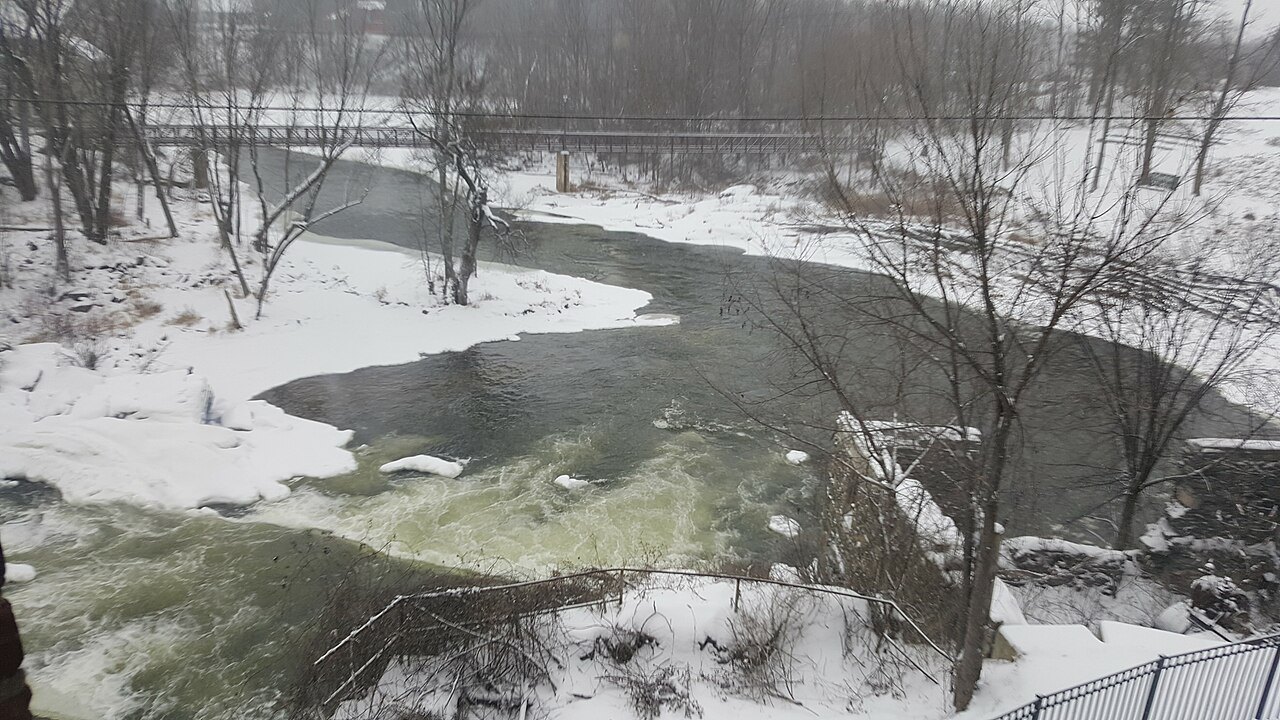 Otter Creek in winter, dark water running between snowy banks.