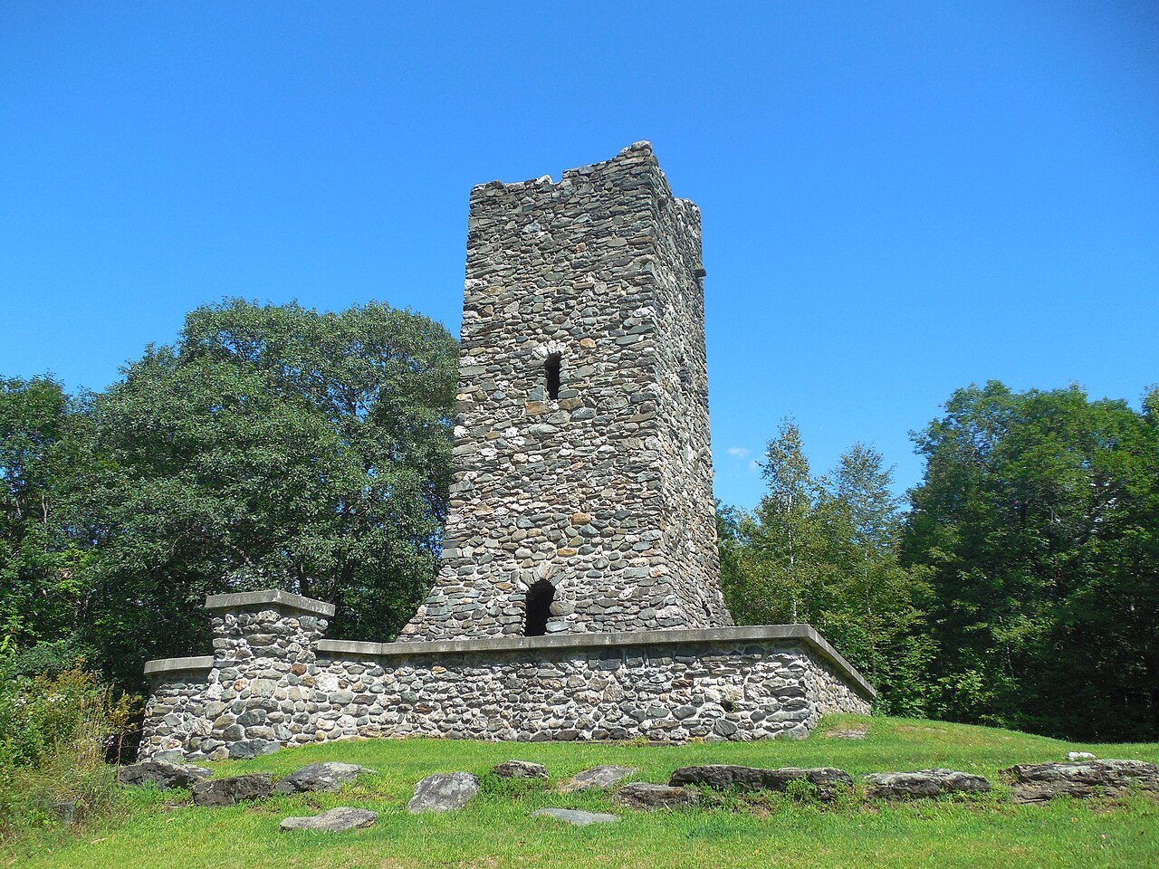 The stone observation tower in Hubbard Park, rising above a low stone wall among trees.