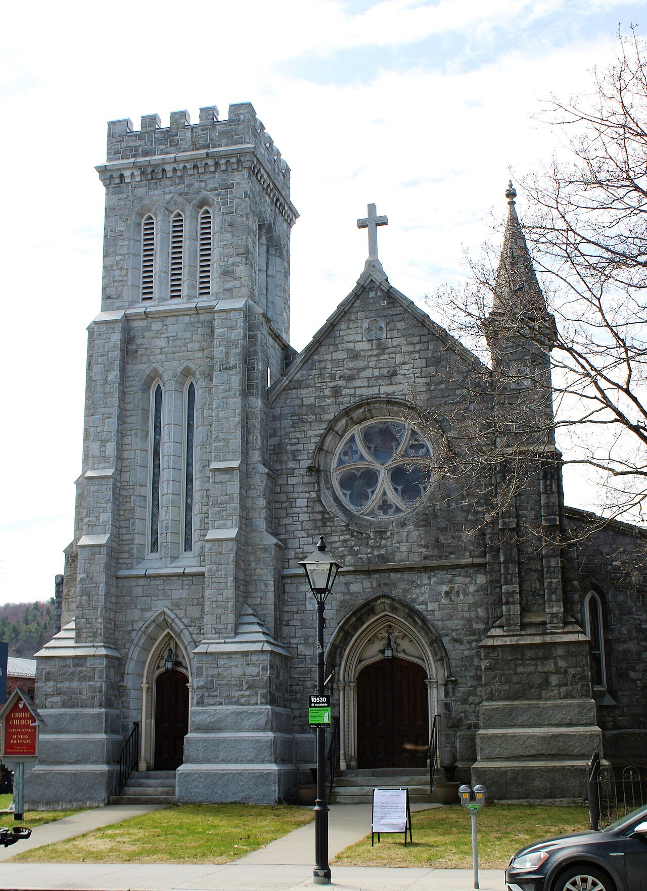Christ Church, a gray stone church with a square tower and a rose window, in Montpelier.