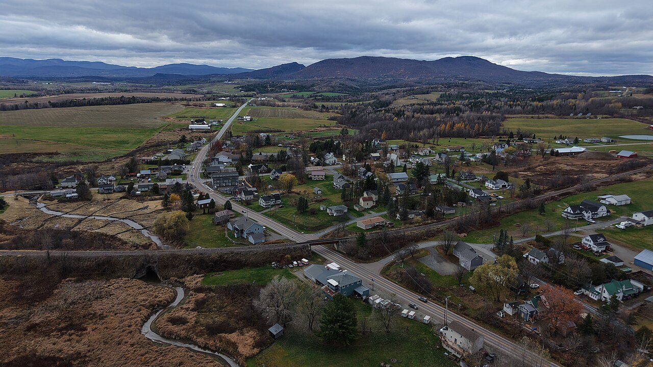 Newport Center from above in autumn, a road and scattered farms under cloud.