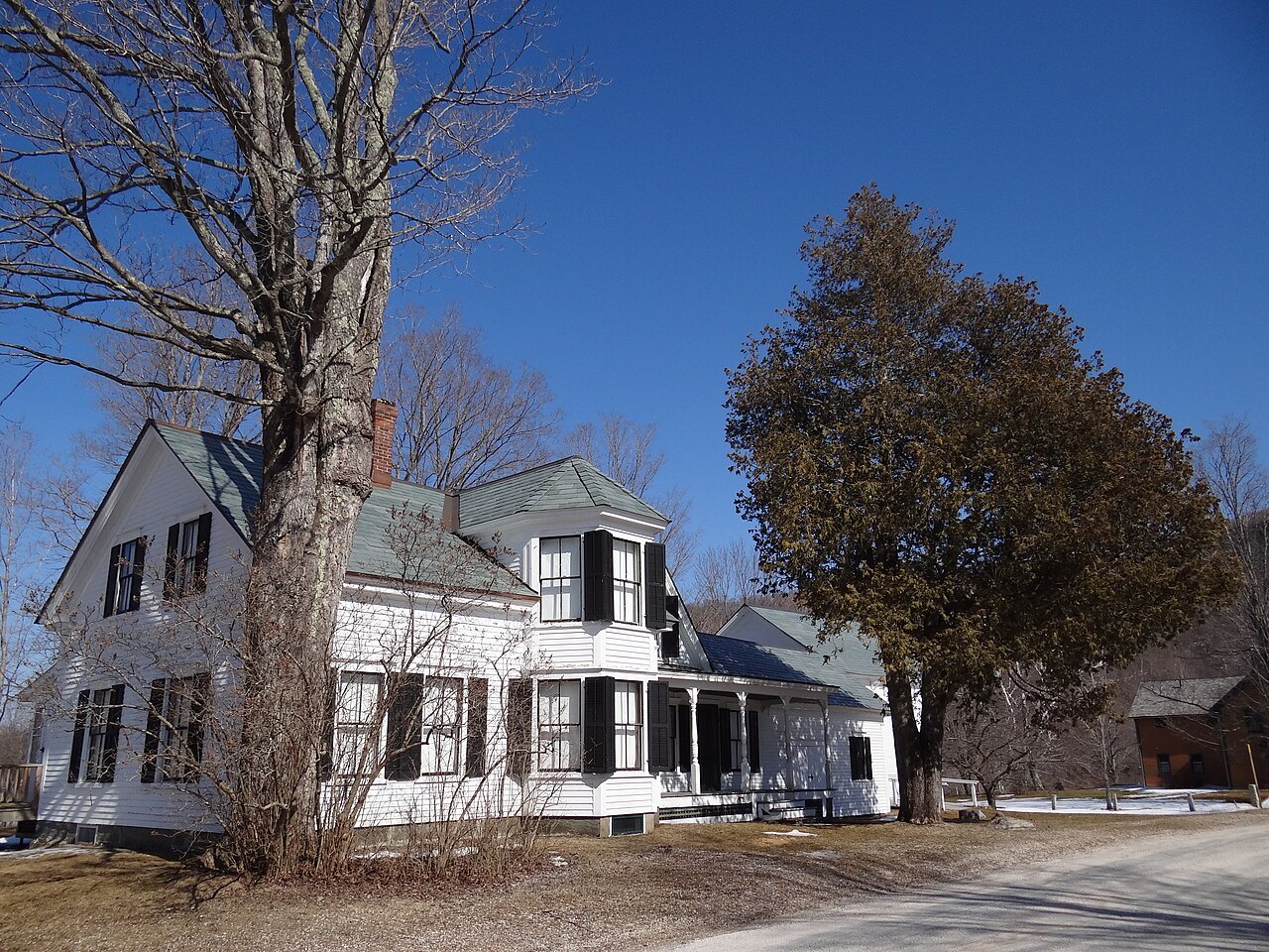 Calvin Coolidge's birthplace, a white house with a porch, under bare trees.