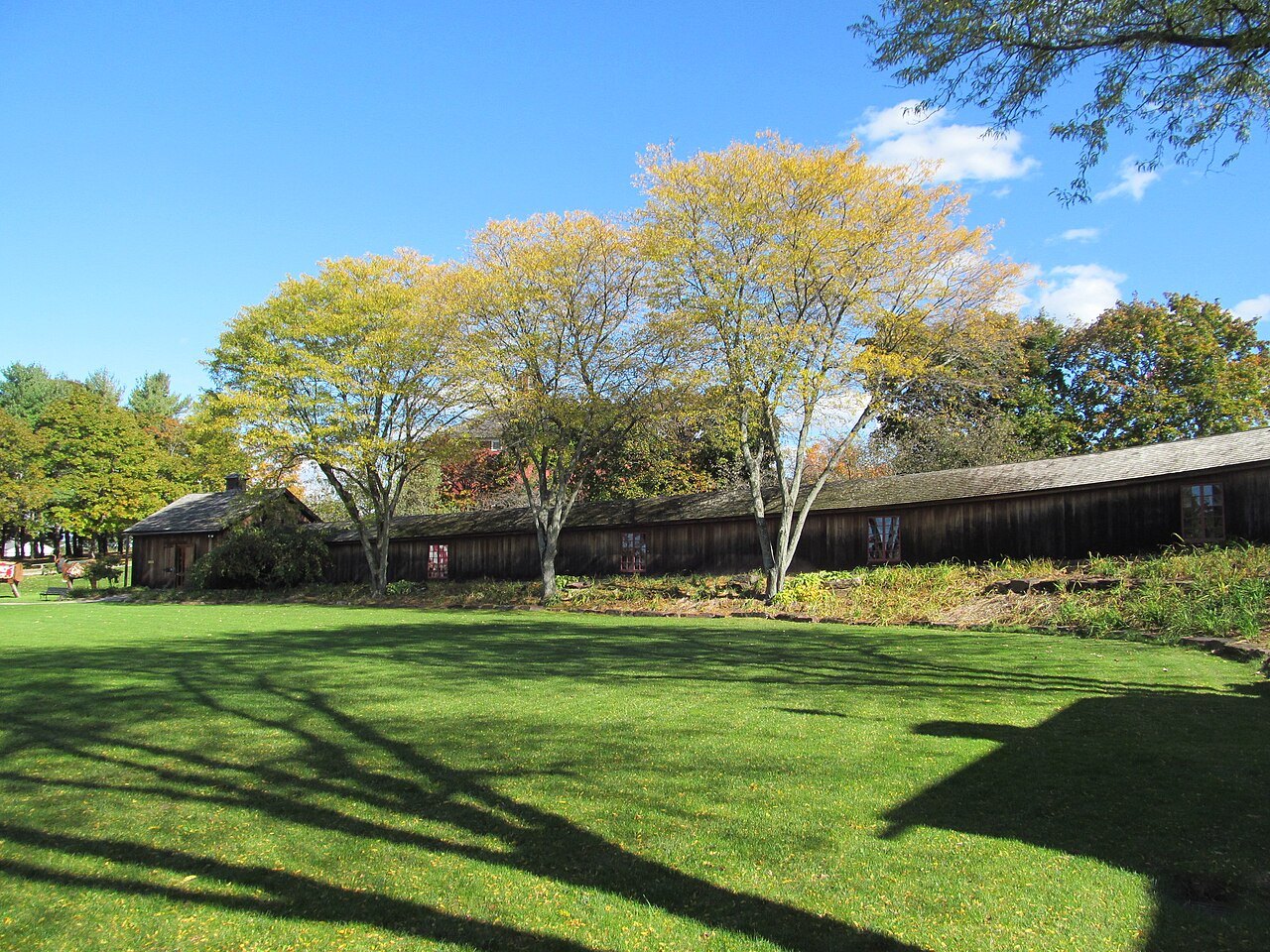 The Circus Building, a long wooden range seen across a lawn.