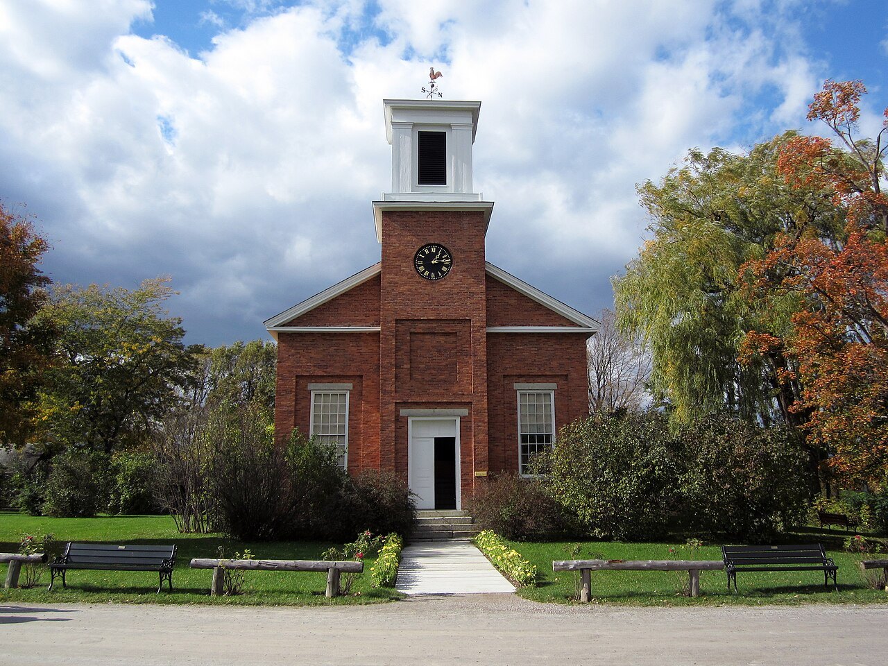 The Charlotte Meeting House, a brick church with a clock and a white belfry.