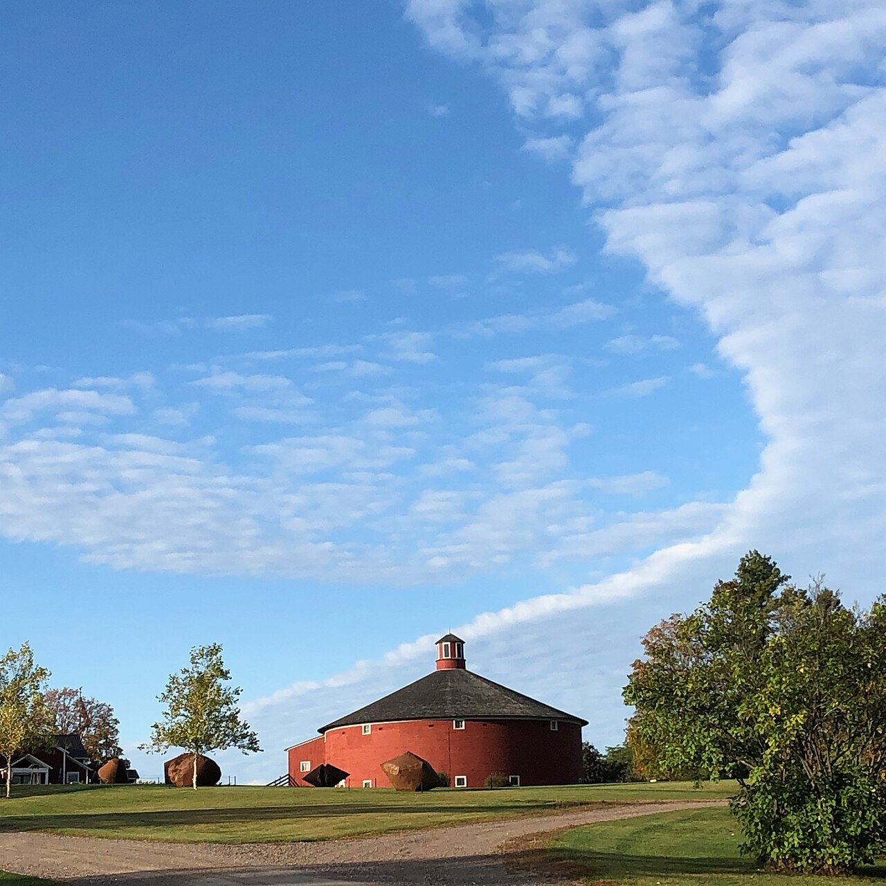 The Round Barn at the Shelburne Museum, red under a wide sky.