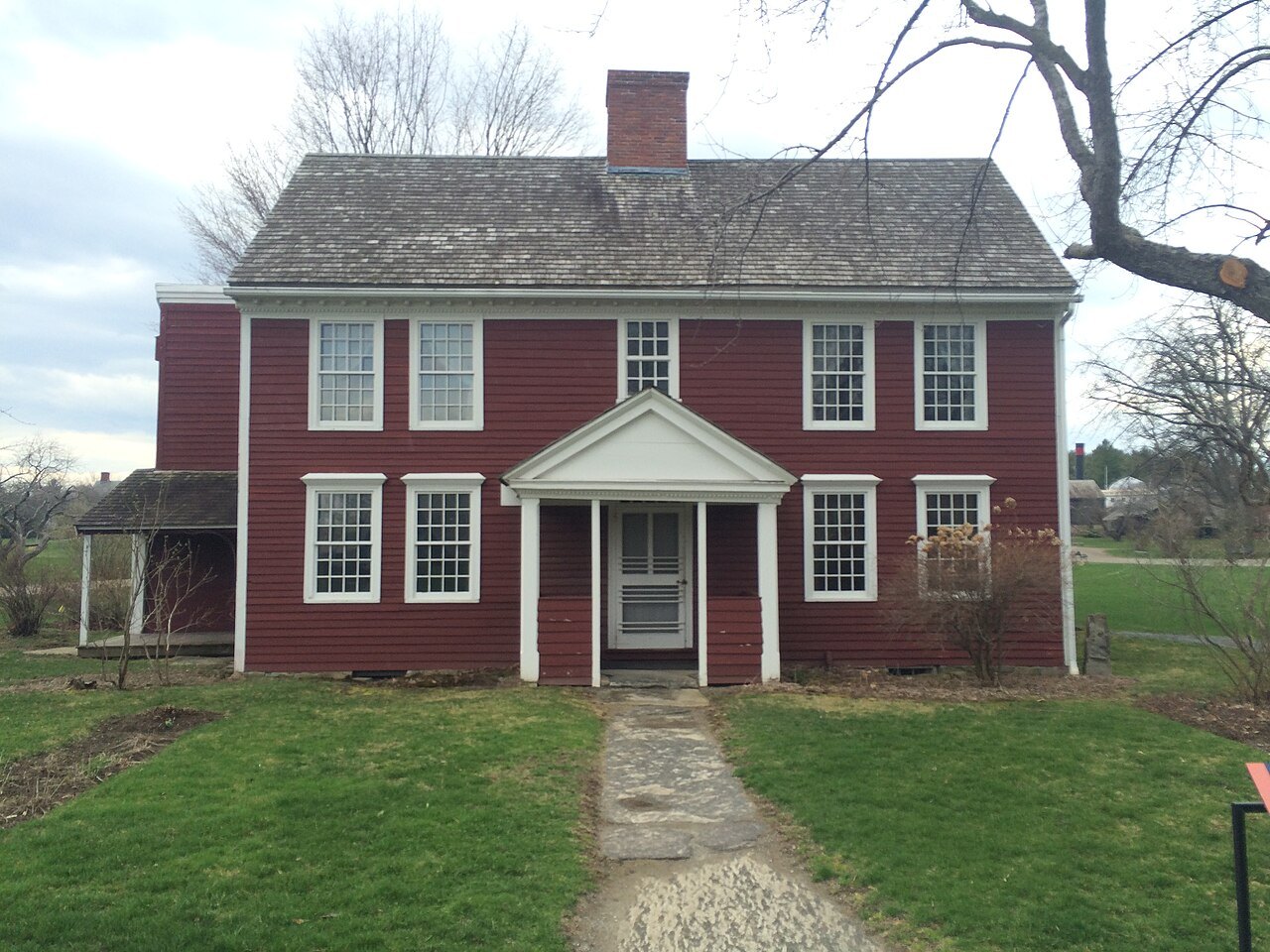 The Dutton House, a red clapboard house with a columned doorway, one of the museum's relocated buildings.