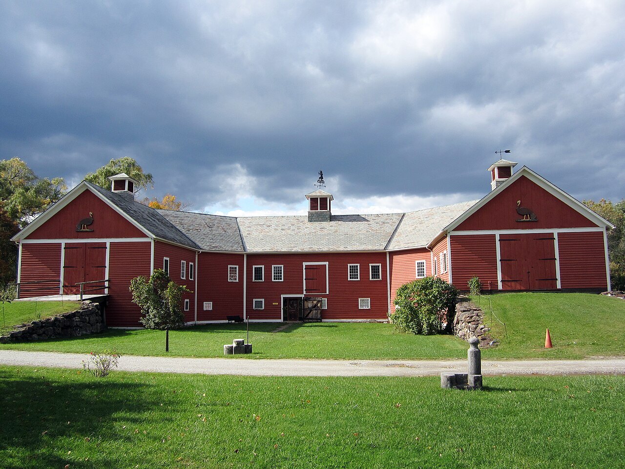 The Horseshoe Barn, red with white trim, under a dramatic sky.