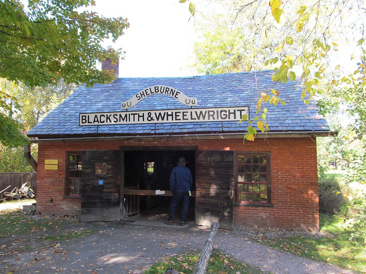 The Blacksmith and Wheelwright shop, a brick building with a painted sign over the door.