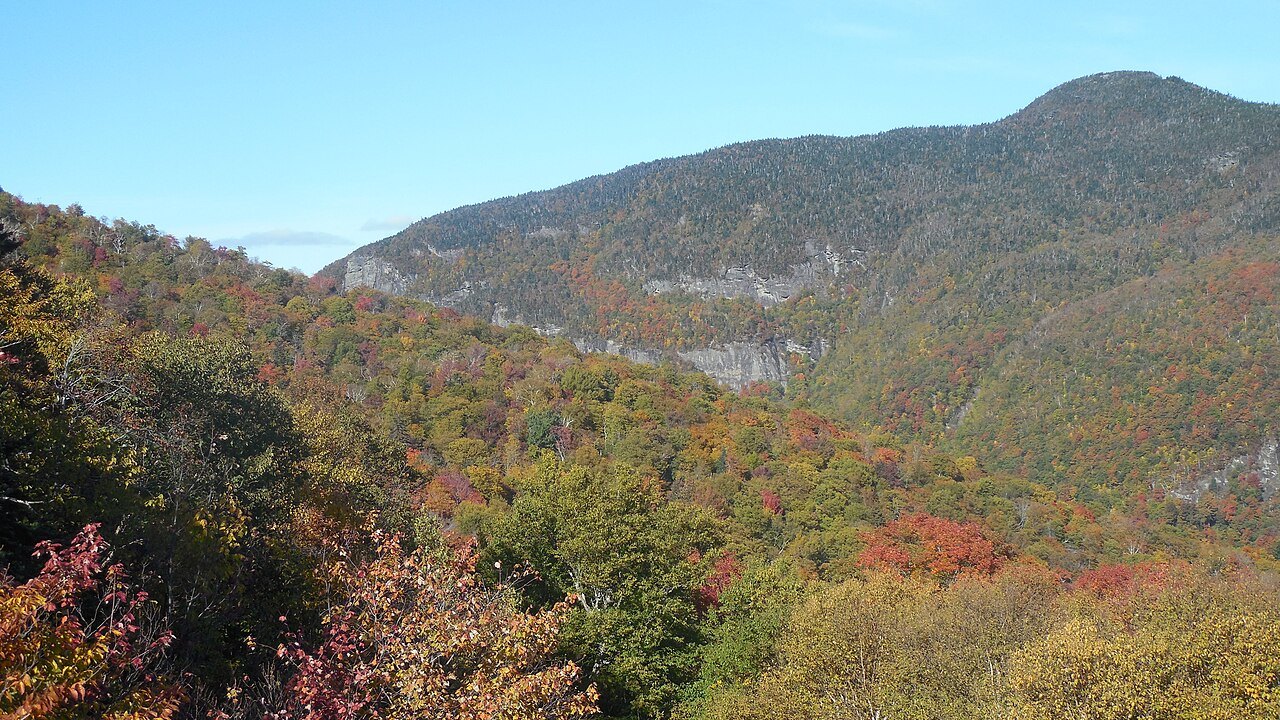 The slopes of the notch in autumn color, with the cliff rising behind.