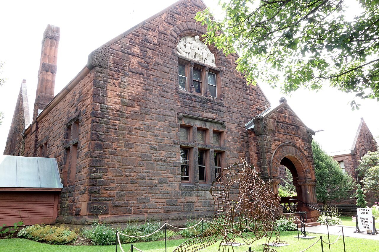 The Fairbanks Museum and Planetarium, red sandstone and an arched entrance among trees.