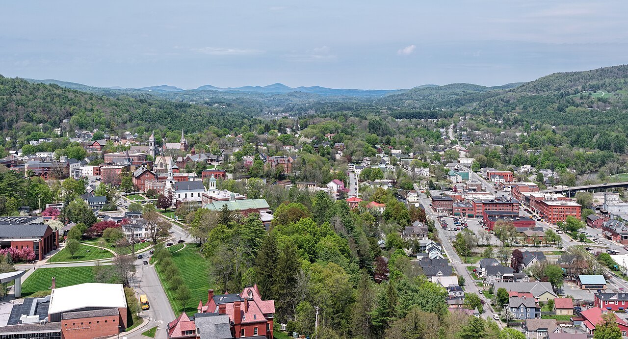 St. Johnsbury in May from above, a main street running through a green valley.