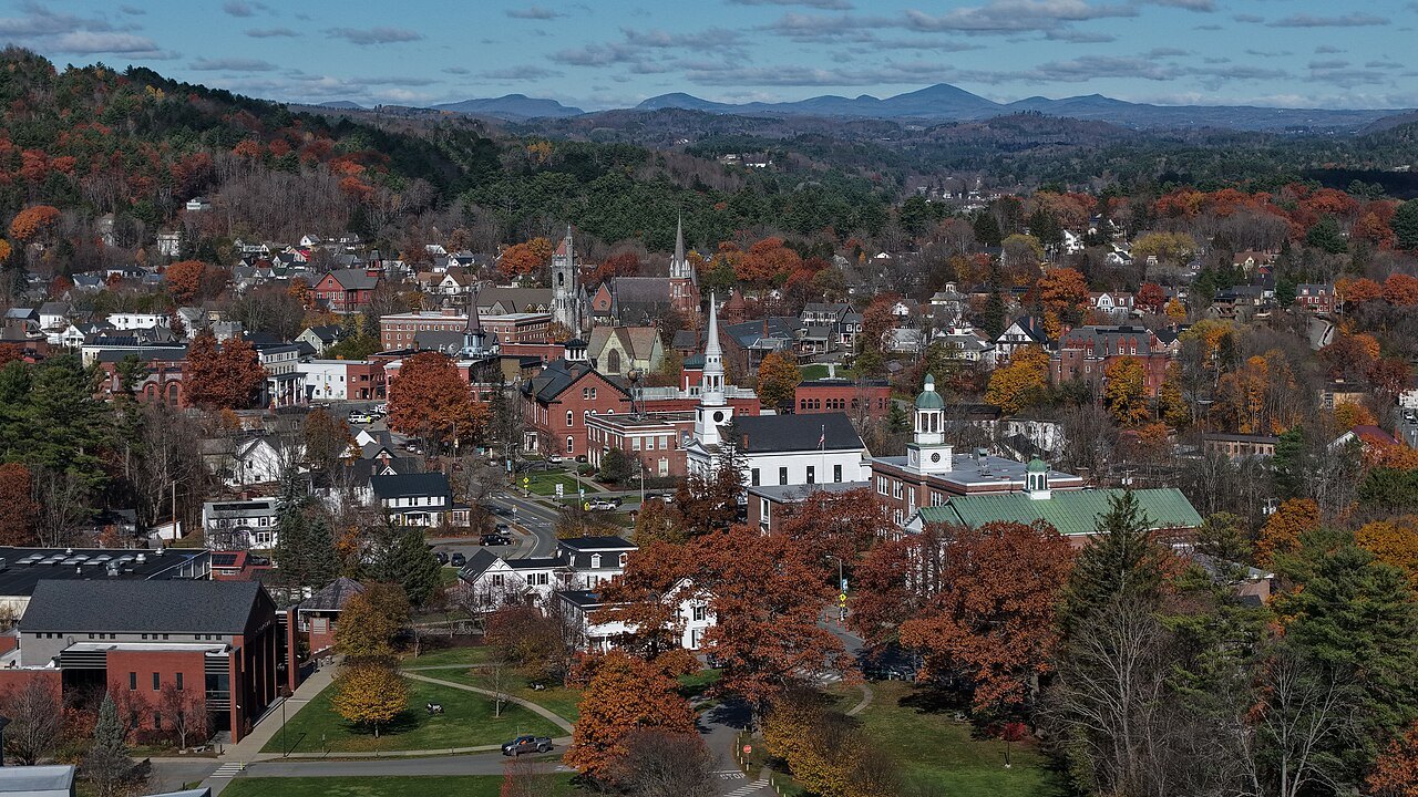 St. Johnsbury from above in autumn, church spires among red and gold trees.