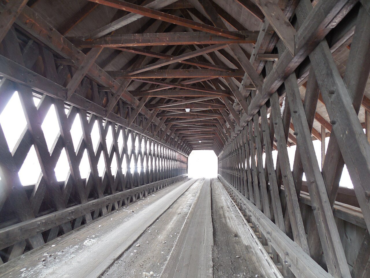 Inside the Middle Bridge, a lattice of timbers framing the bright far end.