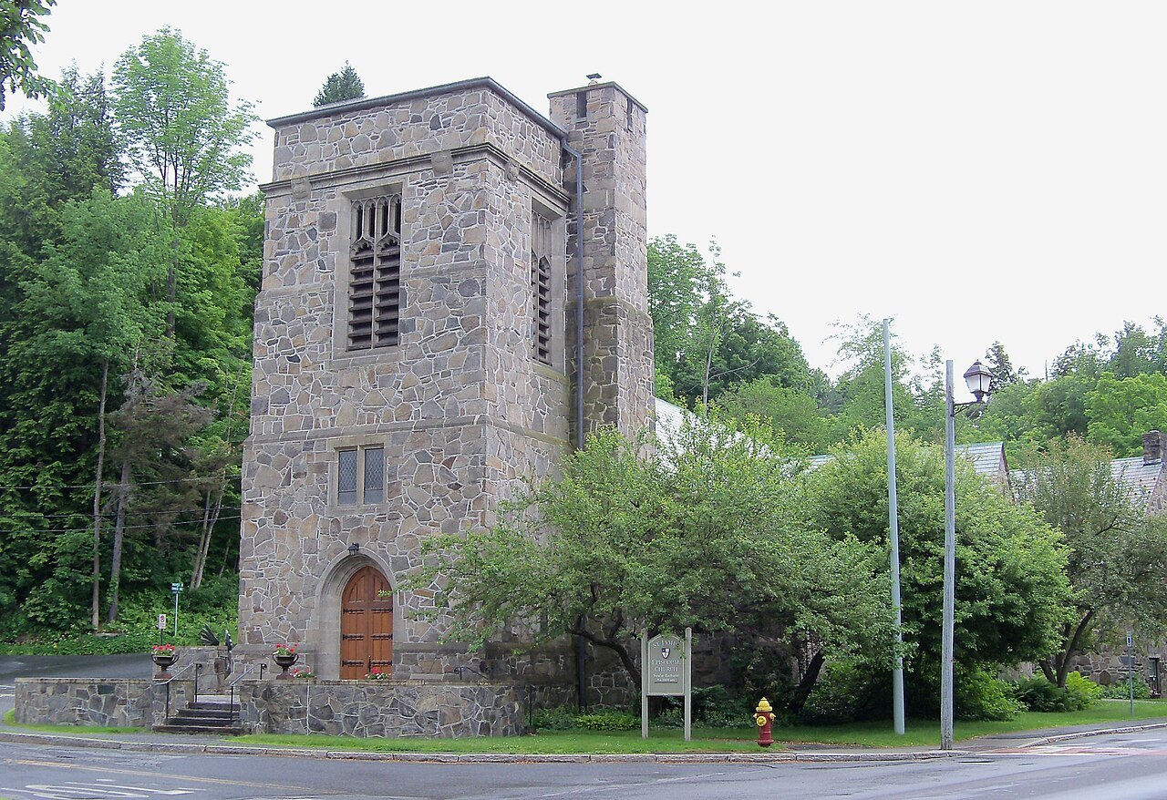 St. James Episcopal Church, a stone tower with an arched red door, on a Woodstock street corner.